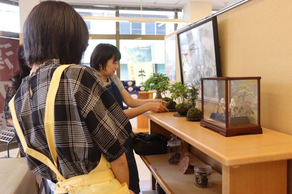 店内に飾られた盆栽作品を紹介する講師