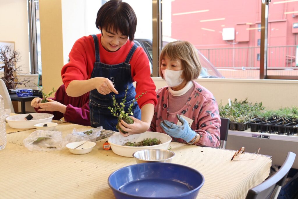 小松先生が参加者に苔玉づくりを指導している様子