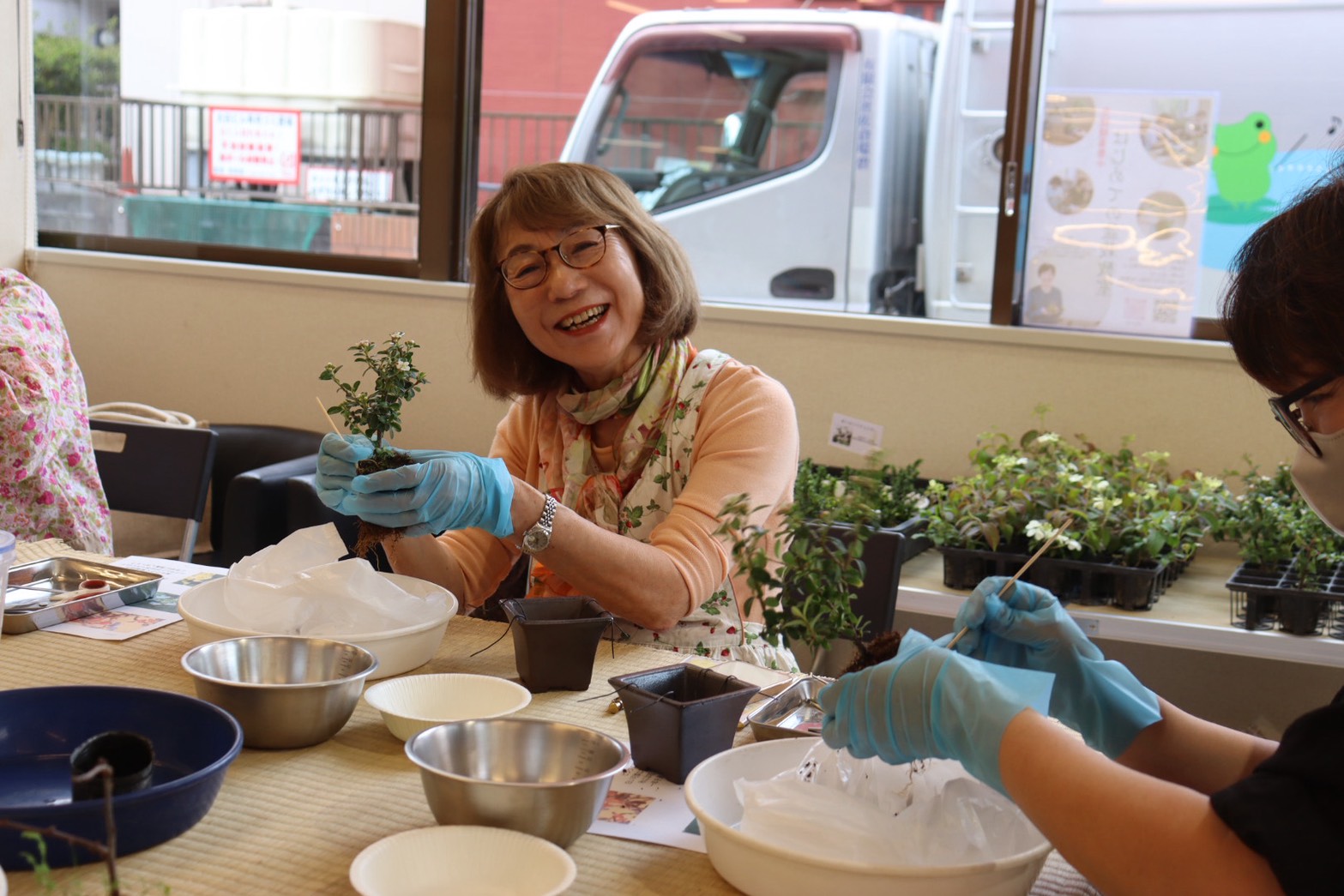 笑顔で盆栽づくりに取り組む参加者